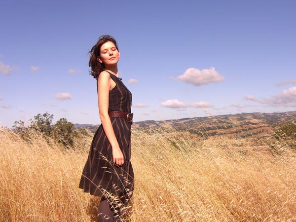 A beautiful Ukrainian girl standing on a grassy land.