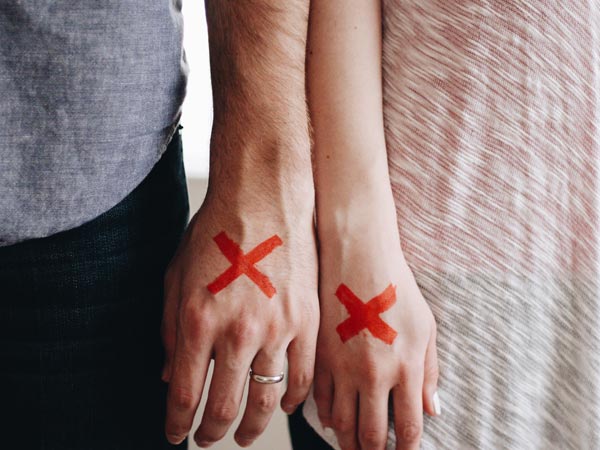 side by side hands of man and woman with marks