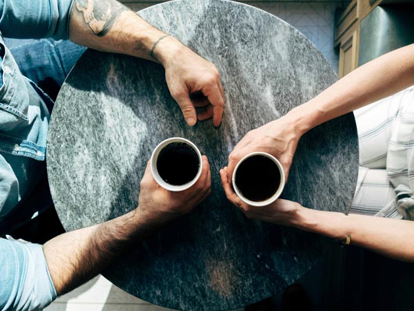 top view of hands of man and woman in table with coffee