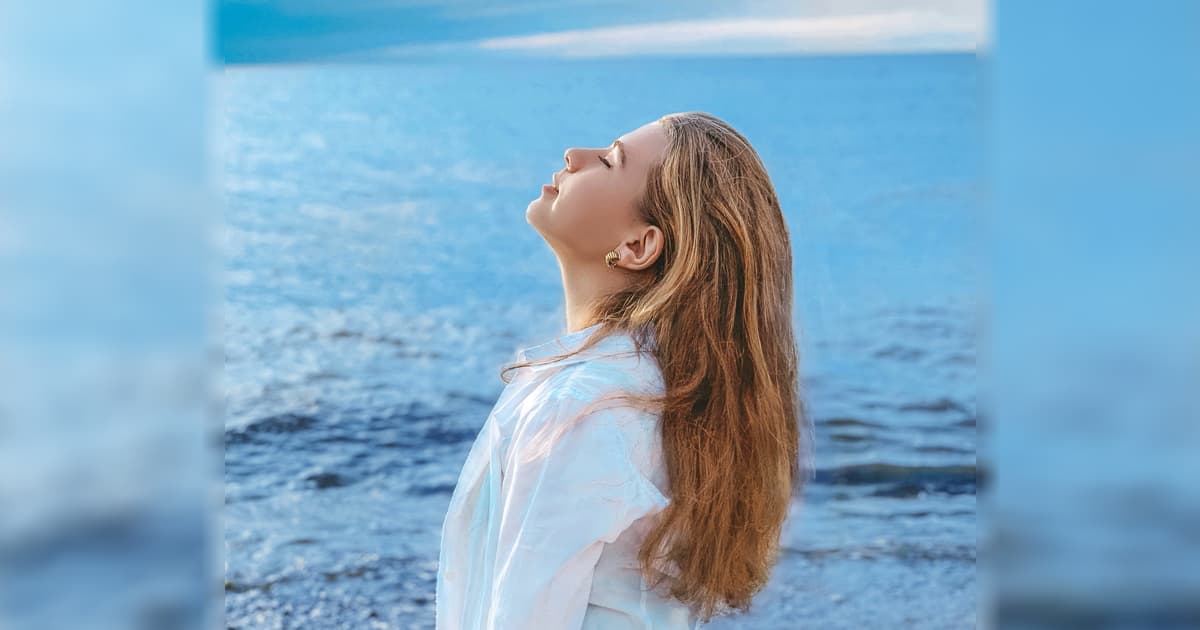 A photo of a woman standing by the peaceful sea