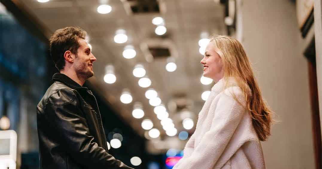 Couple holding hands and smiling at each other.